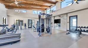A gym with exercise equipment, large windows, and a high ceiling. - Landing | Stunning 2BD, Gym, Yoga Studio (San Marcos)