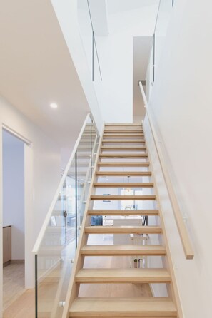 Eine moderne Treppe mit Glasgeländern und Holzstufen.