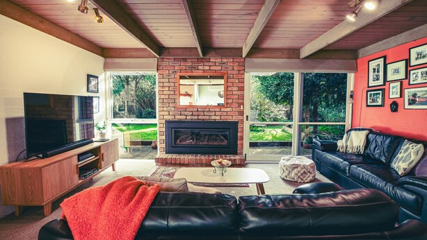 Una sala de estar con chimenea, televisor, sofá y mesa de centro.