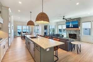 A spacious kitchen with a central island, a dining area with a view, and a living room with a fireplace. - Morning Mist on Keowee (Seneca)