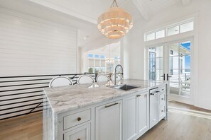 A kitchen with a marble countertop, white cabinetry, a large window, and a hanging light fixture. - Sleeps 22! Private Pool, LSV/Golf Cart, & GULF VIEWS! Steps to Beach! (Santa Rosa Beach)