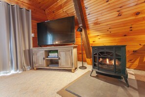 A cozy room with a television on a wooden cabinet, a fireplace, and curtains. - Little Bear Cabin Robbinsville NC (Robbinsville)