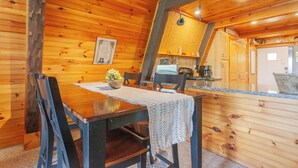 A wooden interior with a dining table, chairs, a kitchen area, and a wooden ceiling. - Little Bear Cabin Robbinsville NC (Robbinsville)