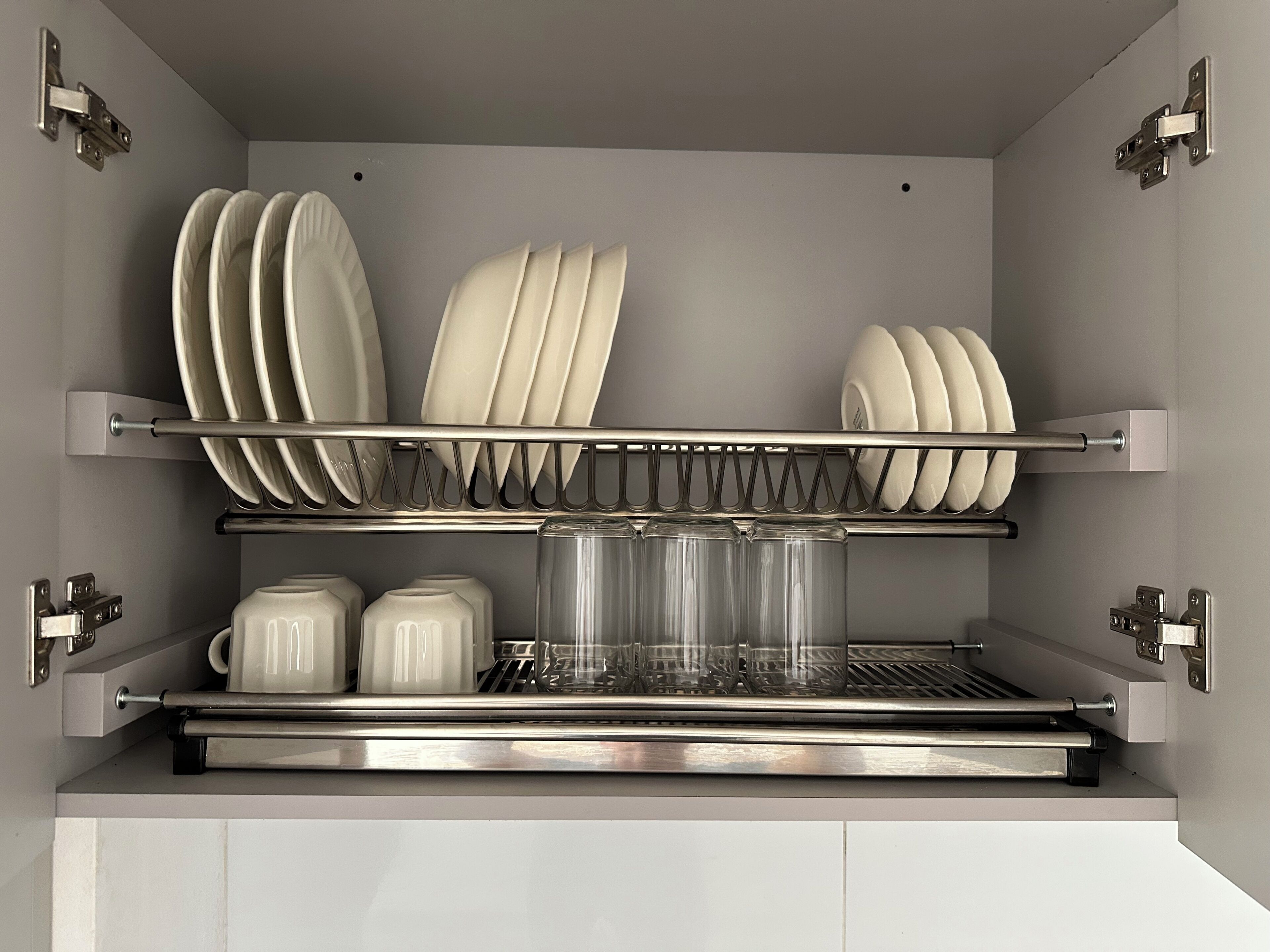 Un lavavajillas con varios cestos para platos y vasos, y un cesto inferior para tazas.