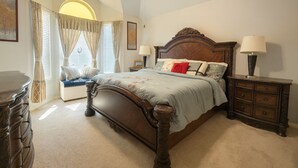 A bedroom with a large bed, a nightstand, a dresser, and a window with curtains. - Spacious 4-bedroom house in friendly neighborhood in Round Rock (Round Rock)