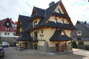 A two-story building with a distinct triangular roof design, labeled 'Villa Bachledom.' - Willa u Bachledów Studio #4 (Zakopane)