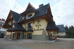 A two-story building with a balcony, a sign reading 'Willa u Bachledom,' and a gravel driveway. - Willa u Bachledów Studio #6 (Zakopane)