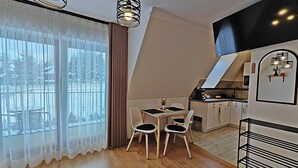 En modern lägenhet med matplats, kök och stora fönster.