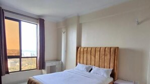 A bedroom with a large bed, a nightstand, a window with curtains, and a view. - Heri Heights Ngong (Ngong)
