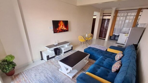 A living room with a sofa, coffee table, TV, and a plant. - Heri Heights Ngong (Ngong)