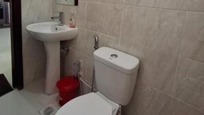 A small bathroom with a toilet, sink, and mirror. - Heri Heights Ngong (Ngong)