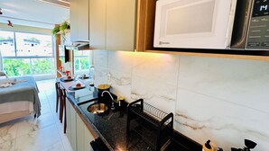 Une cuisine moderne équipée d’un four à micro-ondes, d’un évier et d’un plan de travail.