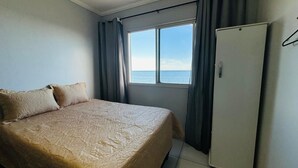 Ein Schlafzimmer mit Bett, Fenster und Kleiderschrank.