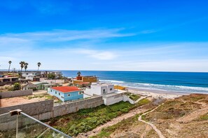Une zone résidentielle côtière avec des maisons, une plage et un ciel dégagé.