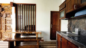 Una cocina con muebles de madera, encimera de mármol y un banco empotrado.