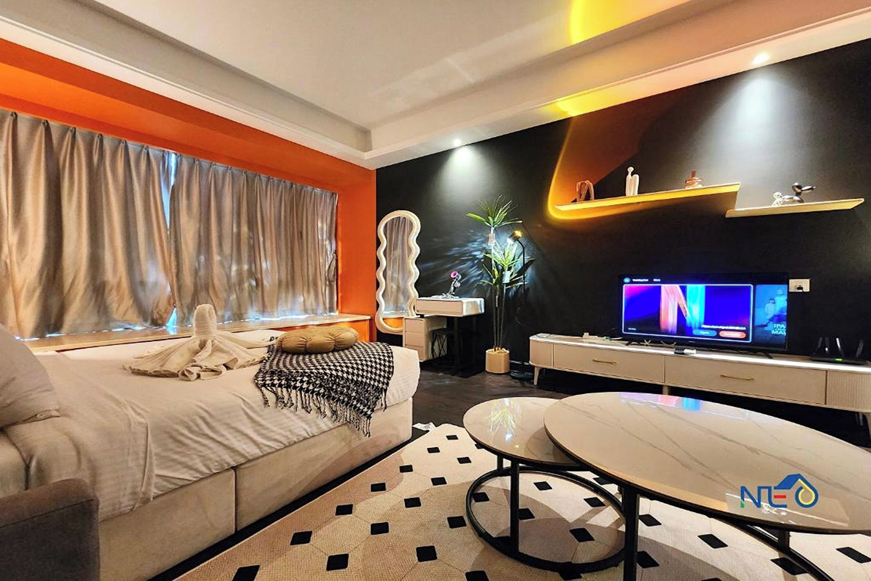 A modern living room with a sofa, a coffee table, a TV, and a plant.