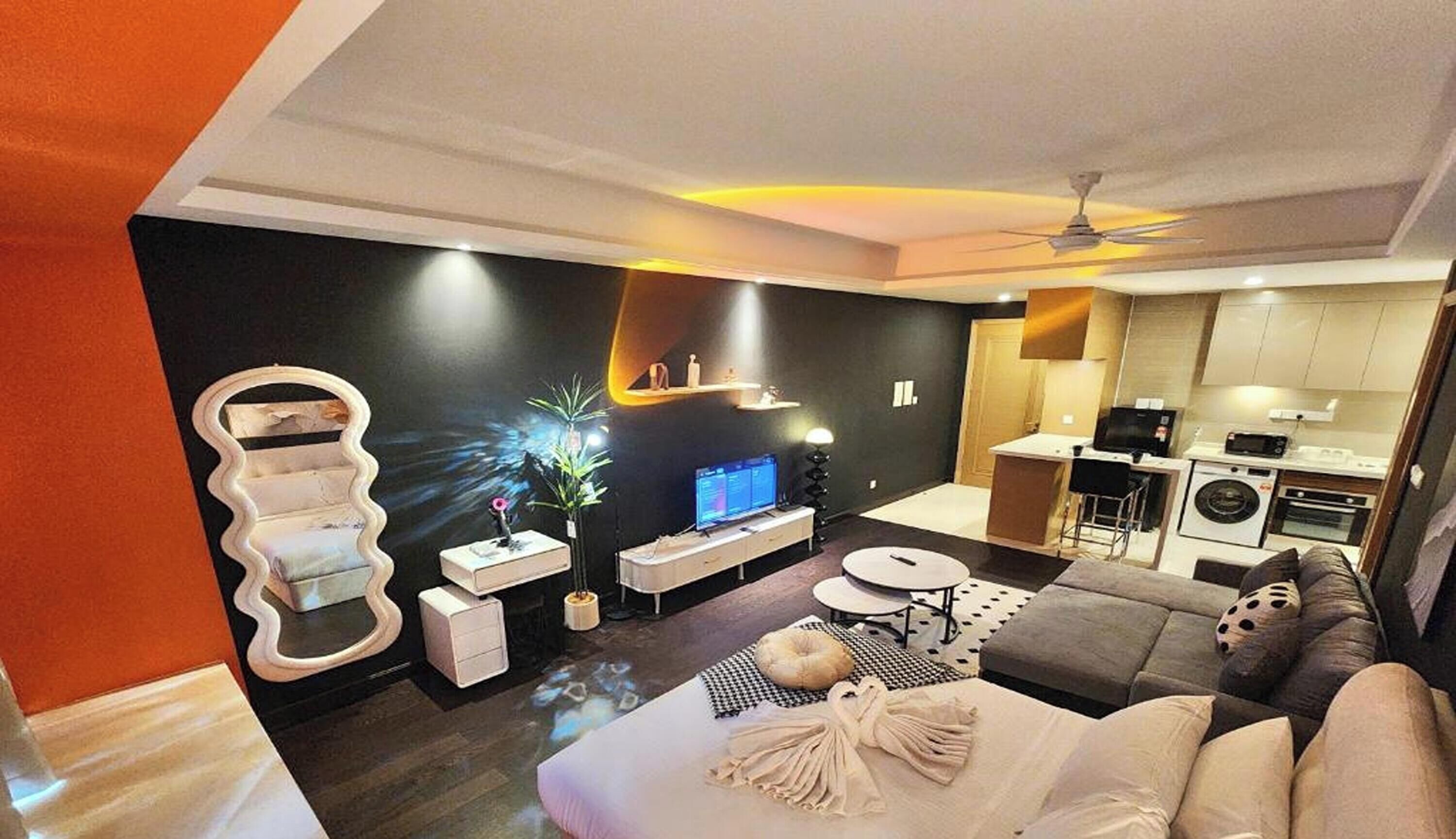 Un salon moderne avec un canapé, un téléviseur et un décor mural original.