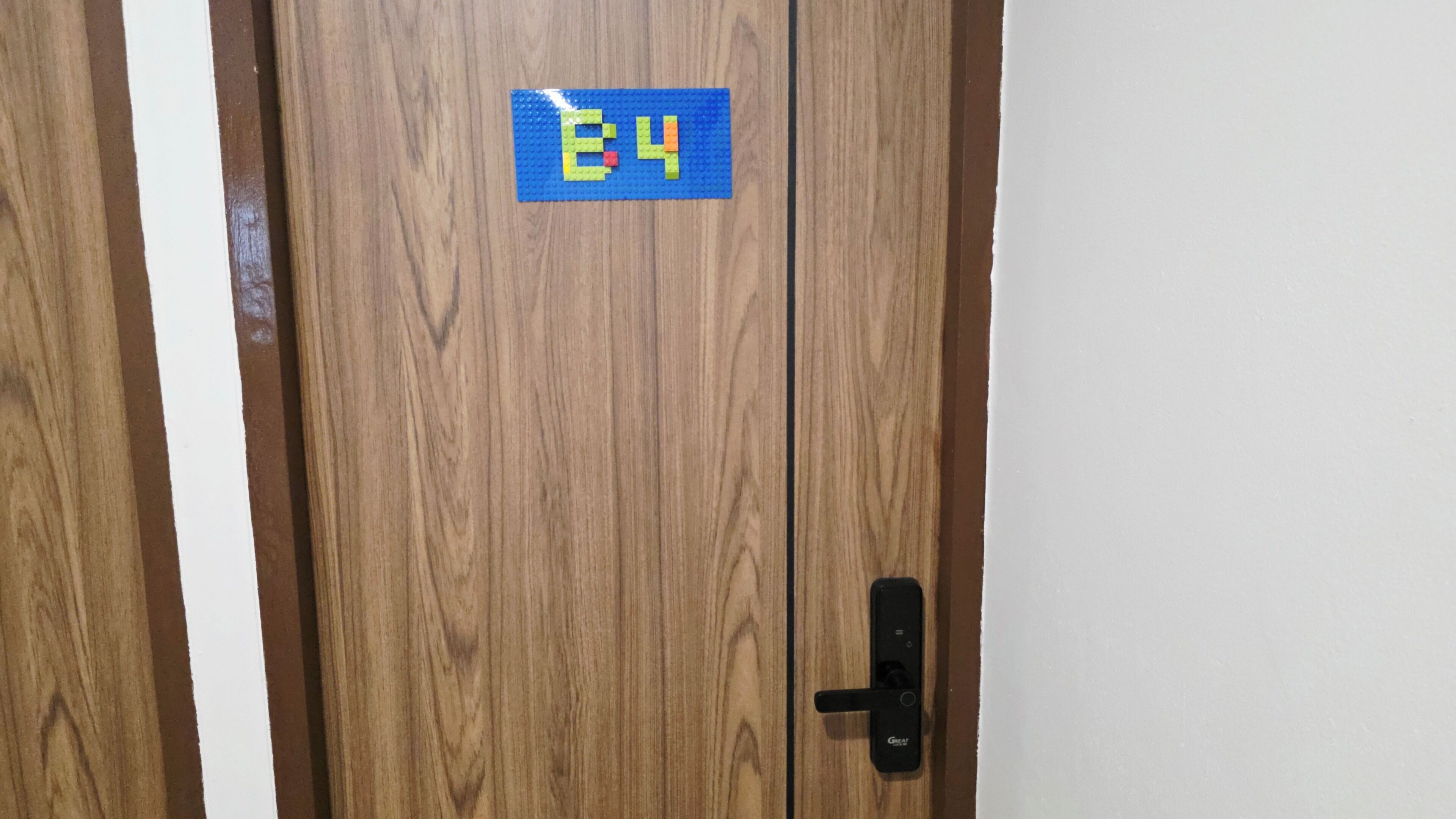 Eine Holztür mit einem blauen Schild, das die Nummer 64 zeigt.