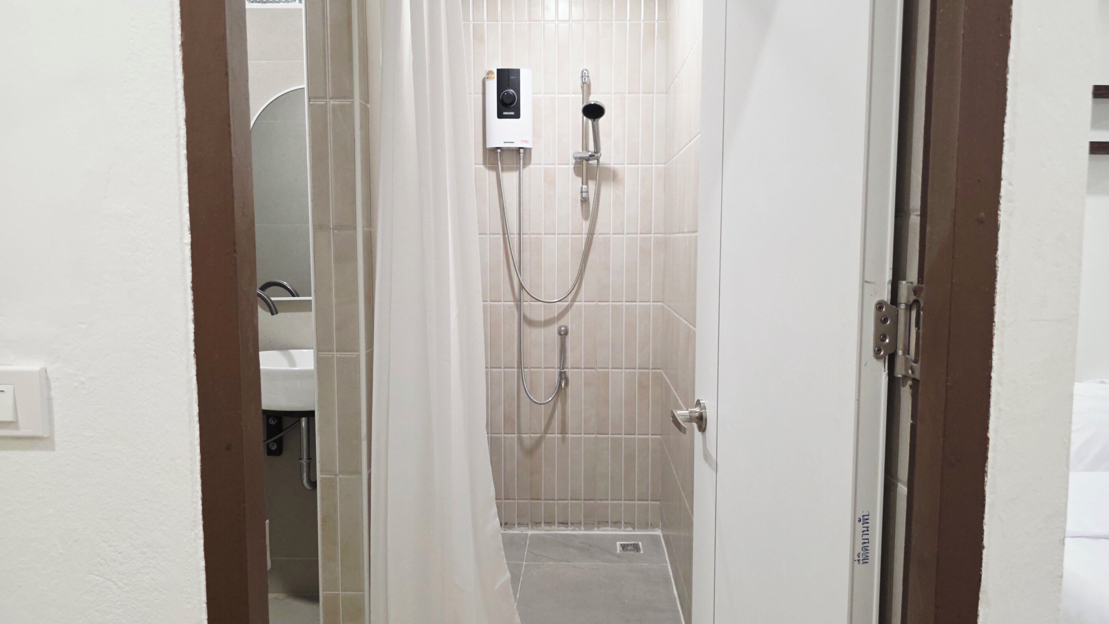 A bathroom with a shower, a toilet, and a sink.
