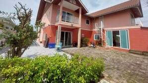 A two-story house with a balcony, a staircase, and a paved driveway. - Baan Pink Pool Villa Pattaya (Bang Lamung)