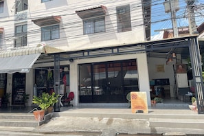 A building with a storefront, large windows, and outdoor seating area. - Dad N Mom'S House By Thongnak Apartment (Pattaya)