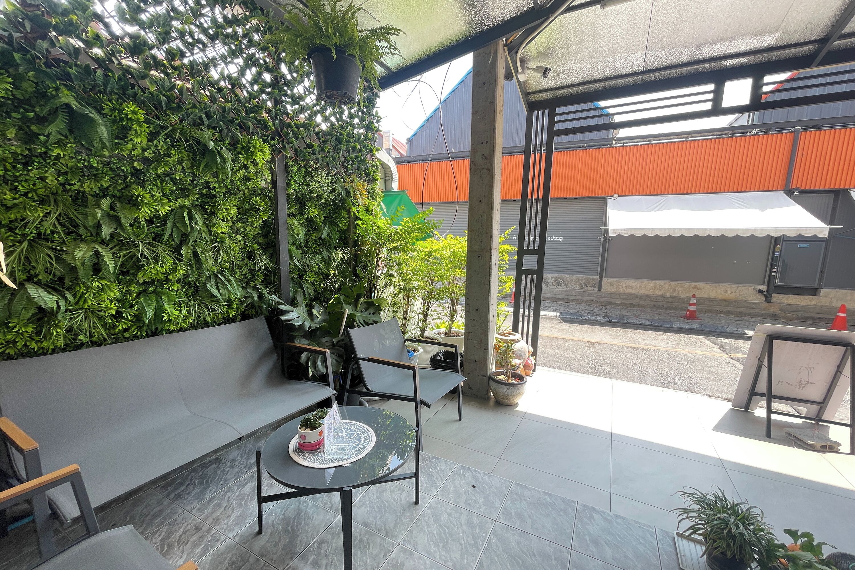 Un espace extérieur aménagé avec des sièges, une table et un mur végétal.
