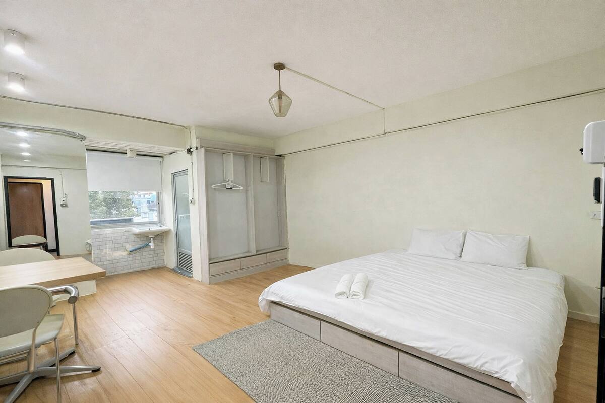 Un dormitorio con cama, escritorio y silla.