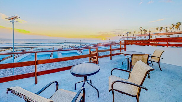 Eine Strandterrasse mit Sitzgelegenheiten und Meerblick.