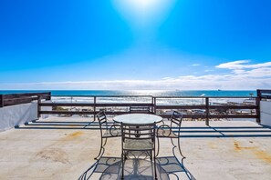 A terrace with a table and chairs overlooking the ocean. - Bright dog-friendly home with heated pool, hot tub, streaming, & ocean views (Rosarito)