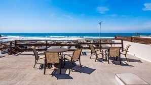 An outdoor seating area with tables and chairs overlooking the ocean. - Dog-friendly villa with heated pool, hot tub, streaming, partial ocean views (Rosarito)