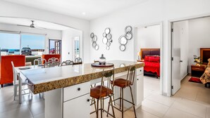 A modern kitchen with a central island, bar stools, and a view of the sea. - Dog-friendly villa with heated pool, hot tub, streaming, partial ocean views (Rosarito)