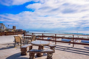 An outdoor seating area with a view of the beach and ocean. - Dog-friendly beachfront villa with pool & hot tub access plus rooftop deck (Rosarito)