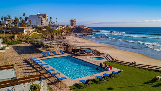 Un resort con piscina, acceso a la playa y vistas al océano.
