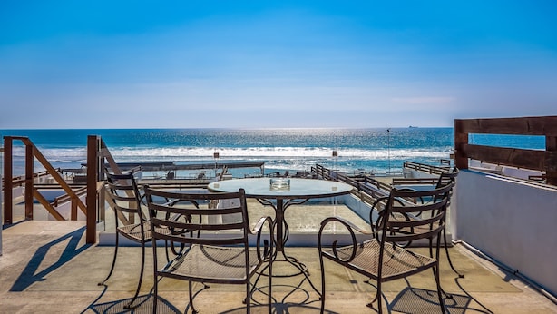 Una terraza con mesa y sillas con vista al océano.