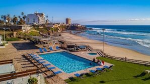Un resort con piscina, acceso a la playa y vistas al océano.