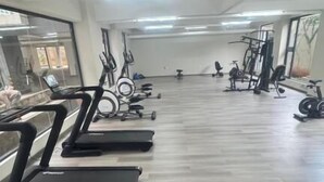 A gym with treadmills, exercise bikes, and weight machines. - Kindaruma Homes Apartments (Nairobi)