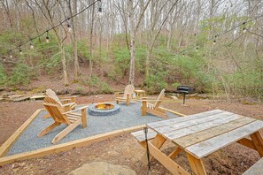 A campsite with a fire pit, wooden chairs, and a picnic table. - Harris Creek Haven by Mountain Oasis | Secluded North Georgia Mountain Getaway (Ellijay)