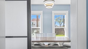 Comedor con una mesa, sillas, un banco y vistas amplias a través de ventanas grandes.