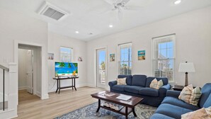 A living room with a blue sofa, a coffee table, and a large painting on the wall.