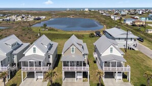 A residential area with houses, a body of water, and a clear sky.
