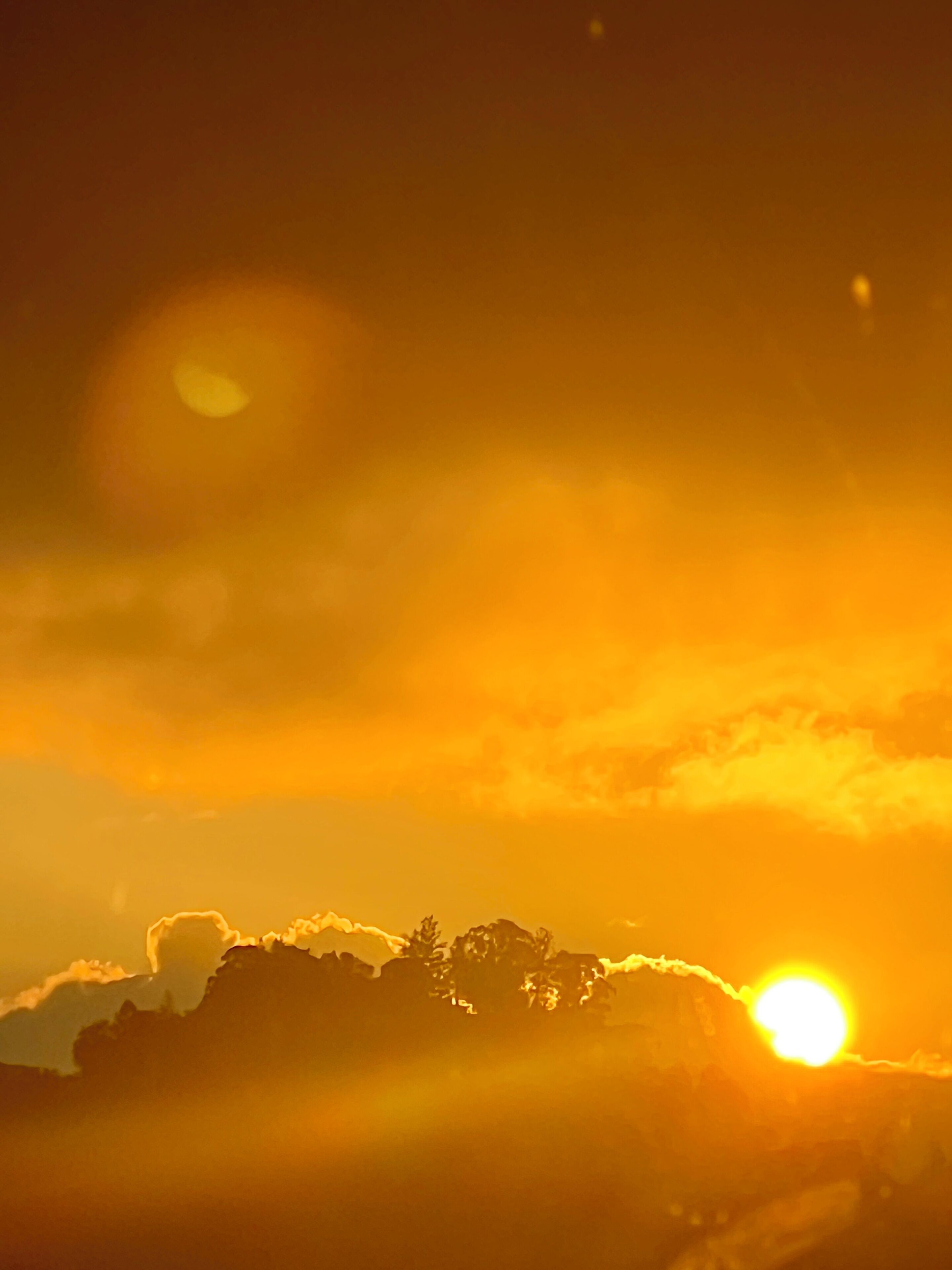 A sunset with clouds and a sun.