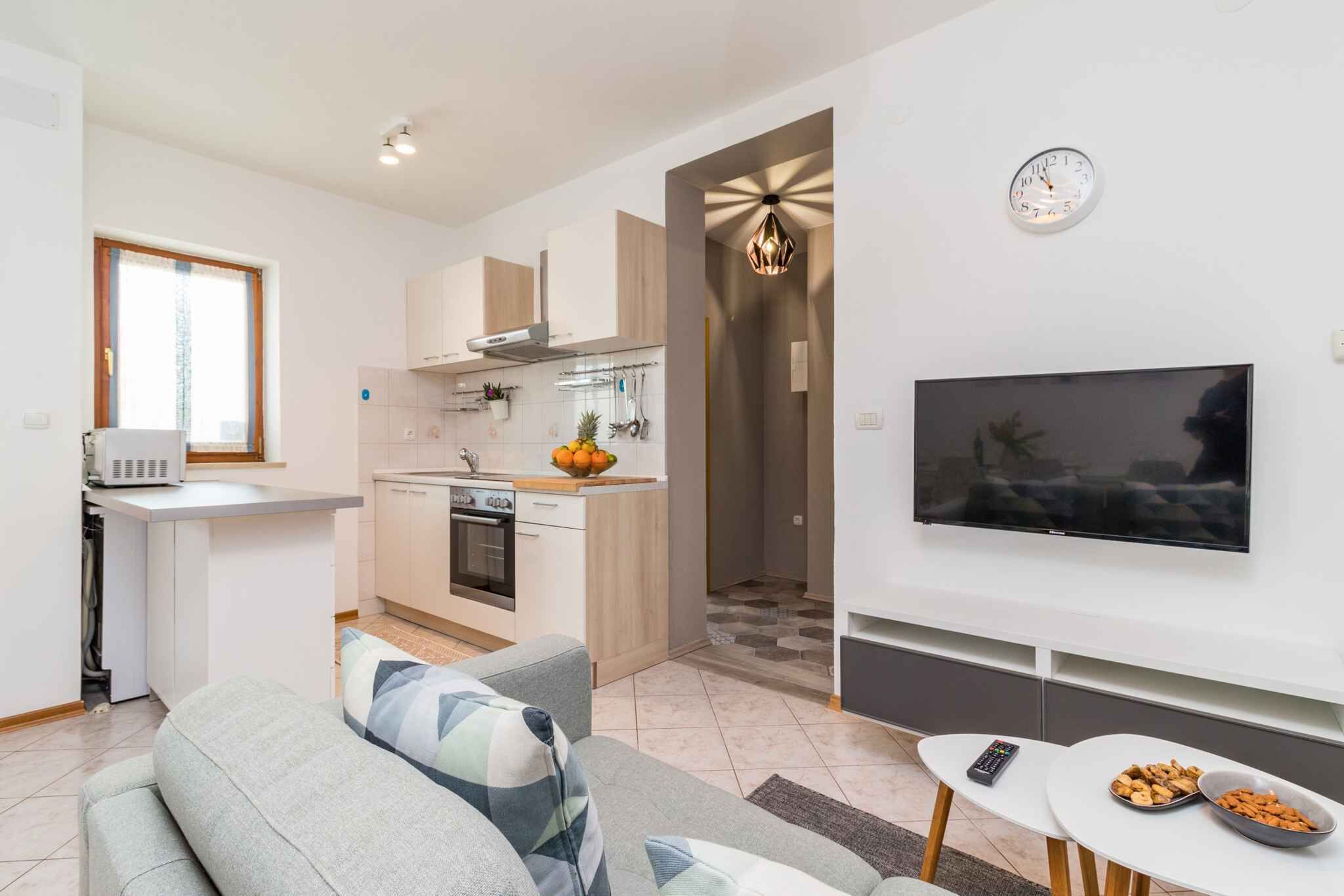 A modern apartment with a kitchen, living area, and a TV.