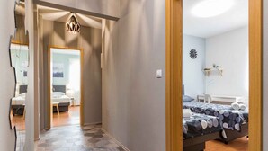 A hallway leading to a bedroom with a bed, a bedside table, and a wall-mounted clock. - Holiday apartment with swimming pool, playground and barbecue (Valbandon)