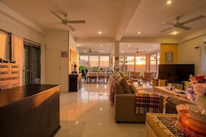 Un amplio salón con sofá, televisor y comedor.
