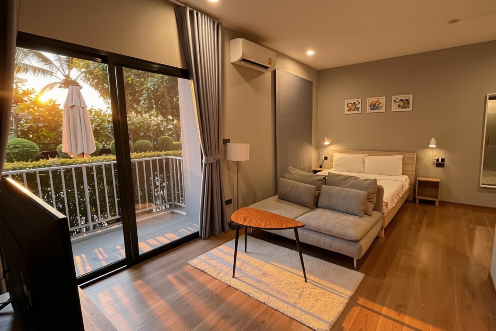 A modern bedroom with a balcony, a sofa, a small table, and a bed.