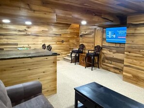 Un área de recepción con una pared de madera, un mostrador de recepción y un espacio de asientos con sillas.