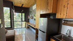 Uma cozinha moderna com armários de madeira, geladeira de aço inoxidável e bancada preta.
