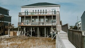 Et toetagers strandhus med balkon og træterrasse.