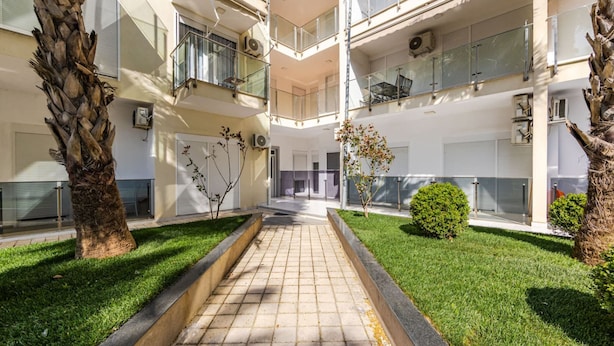 A multi-story building with balconies, a central courtyard, and a pathway. - Beachfront Apartment With Pool Access (Shengjin)