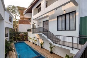 A modern building with a swimming pool, outdoor staircase, and potted plants. - Casa Solana 4bhk Villa w Private Pool nr Candolim (Candolim)